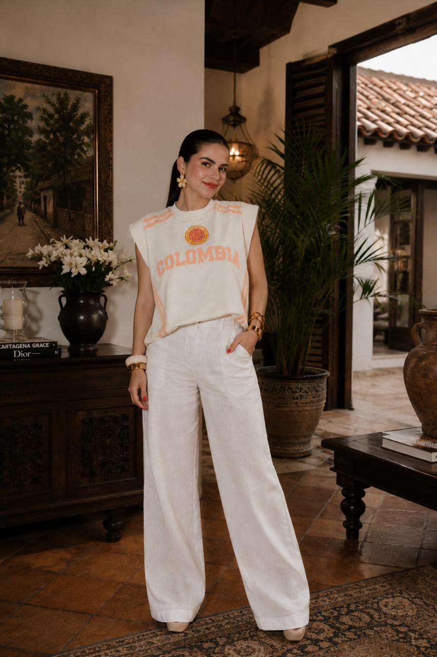 It Girl Colombia Sport tee styled with white wide-leg pants in colonial home — May Palomino